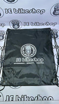 Black drawstring bag with 'JE Bikeshop' logo on a branded background