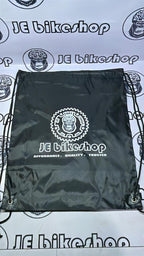 Black drawstring bag with 'JE Bikeshop' logo on a branded background