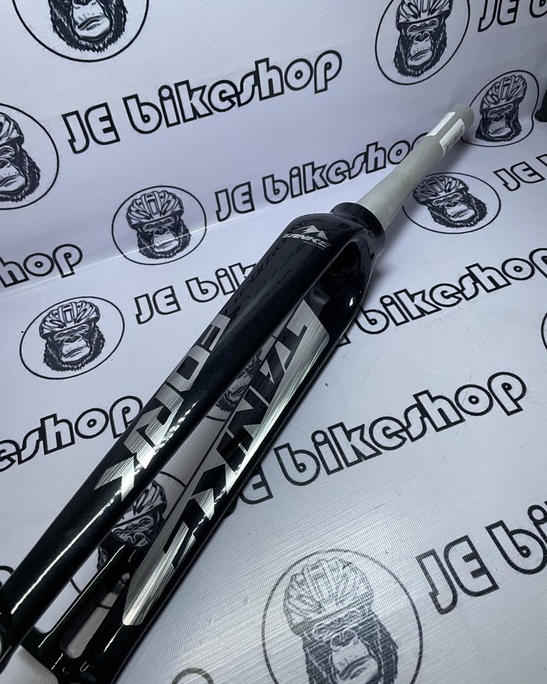 Bicycle fork on a white background with 'JE bike shop' branding.