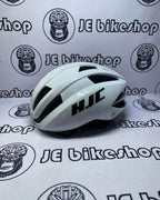 White bicycle helmet with black logo on a white background with 'JE bikeshop' branding.