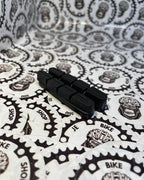 Black carbon brake pads for rim brakes on bicycles.